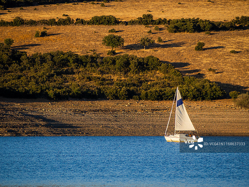 在栓皮栎林中水库航行的帆船图片素材