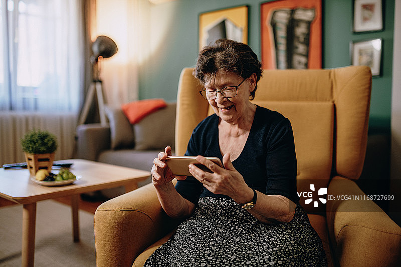 愉快的妇女在家里用手机进行视频通话图片素材