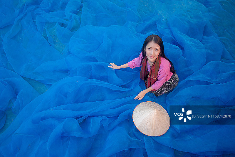 美女在湖边整理渔网图片素材