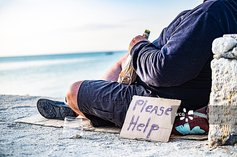 海滩上需要帮助的中年男人身体局部图片素材