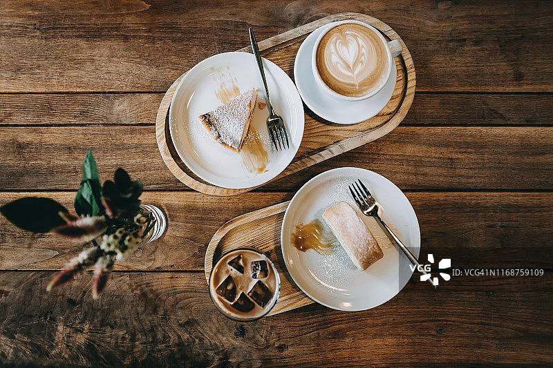 咖啡馆桌子上新鲜出炉的咖啡和蛋糕的俯视图图片素材