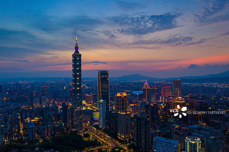 暮光日落时分，从空中俯瞰中国台湾台北市信义区商业中心的天际线和摩天大楼，灯光闪烁图片素材