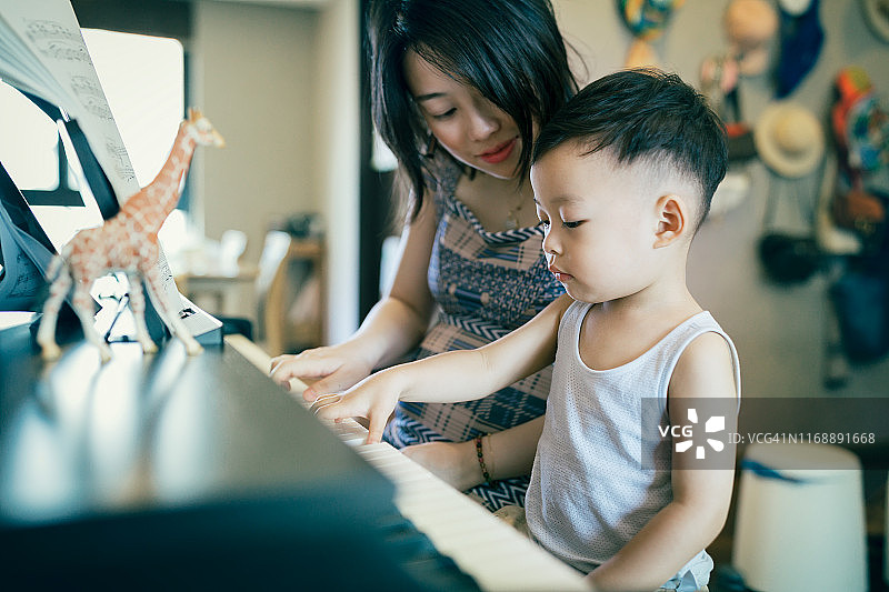 中国母亲教儿子弹钢琴图片素材