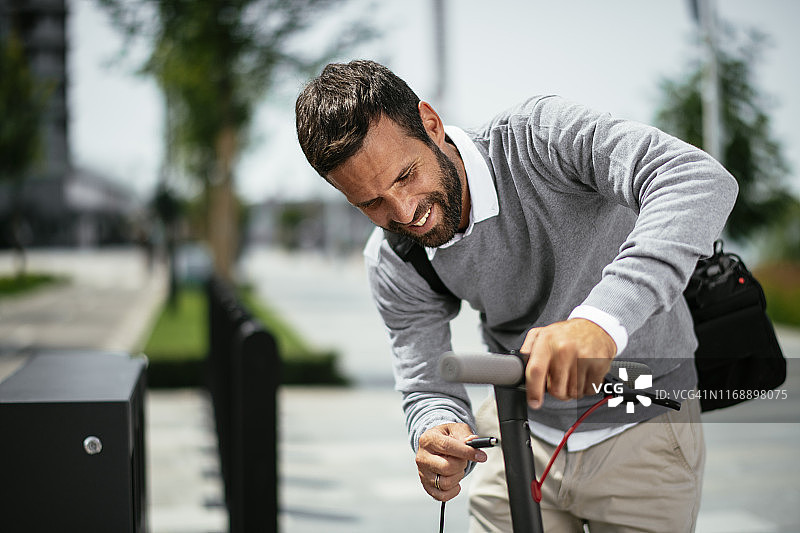为电动滑板车充电的商人图片素材