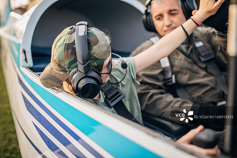 小女孩和飞行员坐在驾驶舱内图片素材