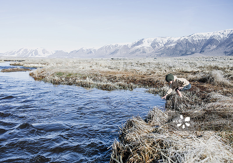 男孩站在美国加利福尼亚州猛犸湖的河边图片素材