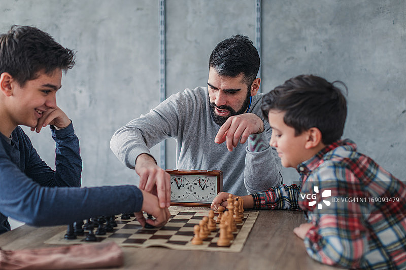 两个男孩和一位国际象棋老师下棋图片素材