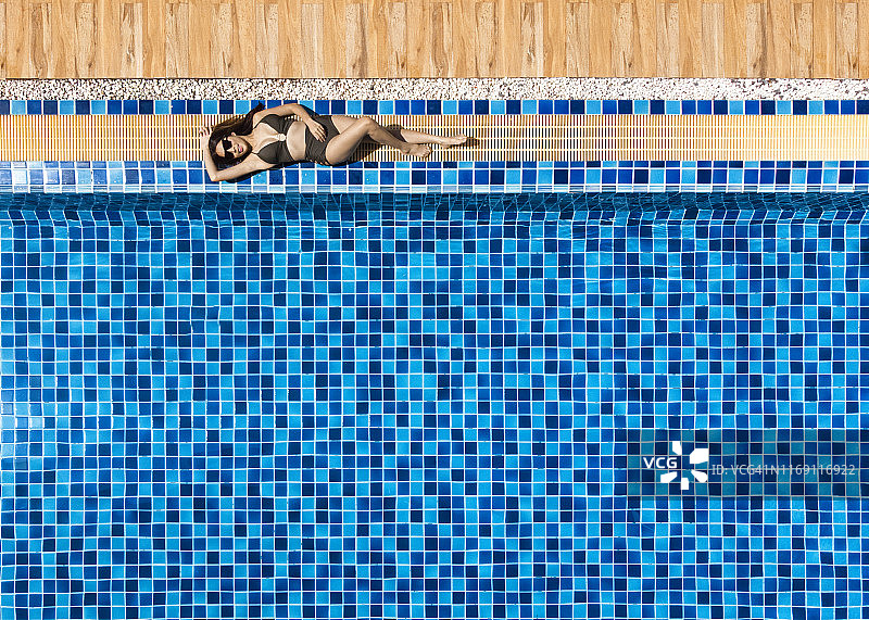 女人在游泳池放松和躺着图片素材