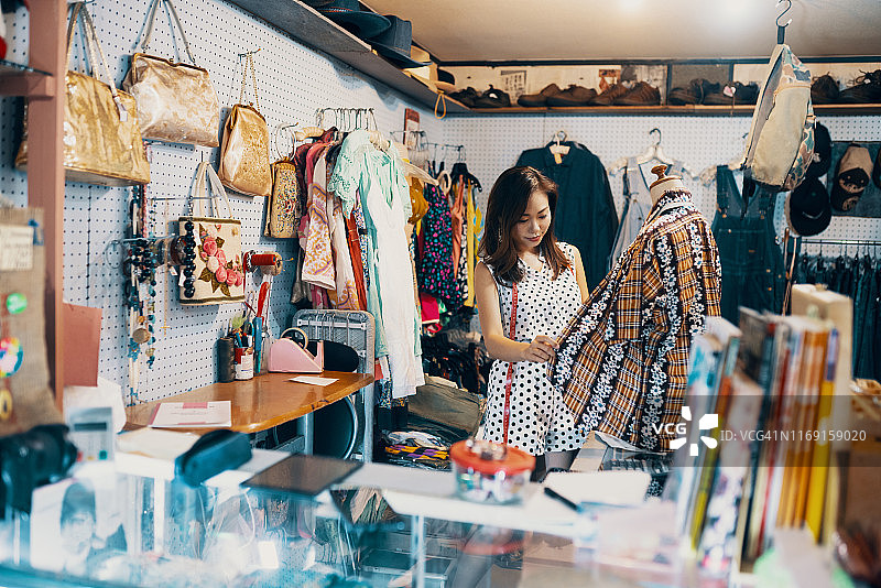 年轻女人在复古服装店购物图片素材