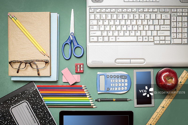 绿色黑板上的笔记本电脑和学习用品图片素材