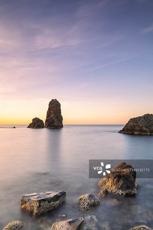 意大利西西里卡塔尼亚省阿奇特雷扎的独眼巨人岩石柱，日出时分图片素材