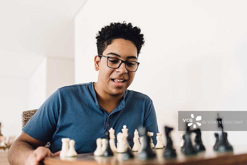 沉迷于国际象棋游戏的青少年男孩图片素材