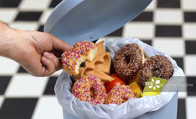 抵制诱惑，将诱人的食物扔进垃圾桶图片素材