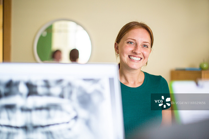 在牙科诊所接待处微笑的女人图片素材