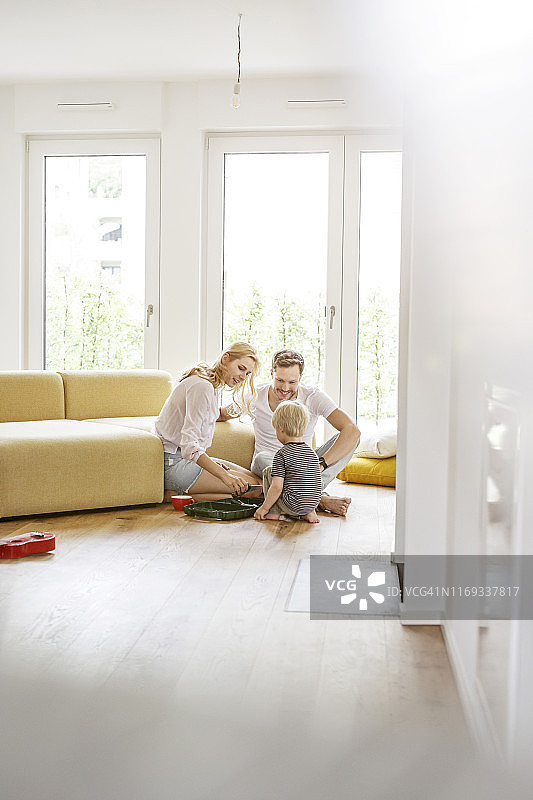 幸福家庭与儿子在新家客厅玩耍图片素材