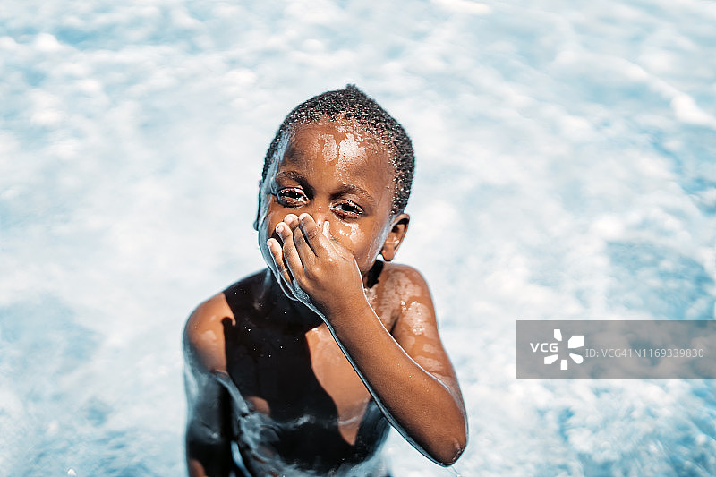 在游泳池里玩耍的非洲儿童，捏着鼻子图片素材