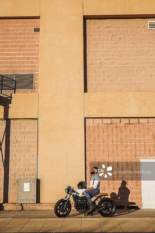 男人晚上坐在摩托车上放松图片素材