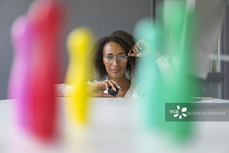 年轻自由职业者在办公桌上玩迷你图钉图片素材