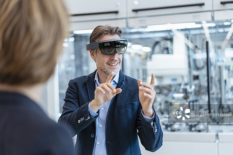 佩戴AR眼镜的商人和在现代工厂的女商人图片素材
