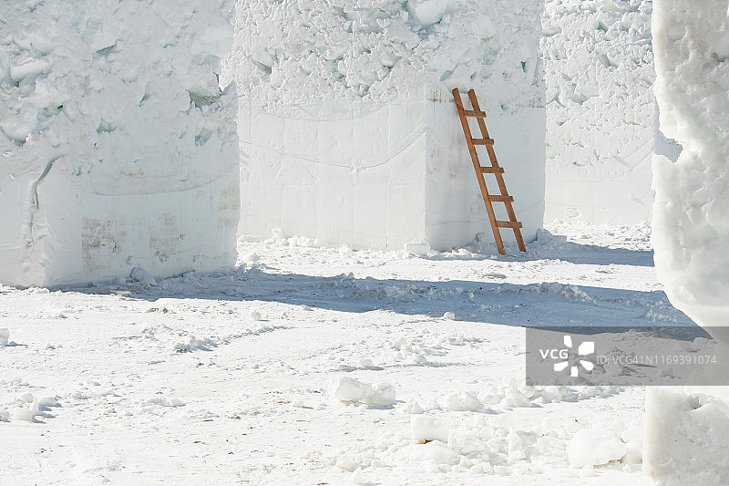 倾斜在方形雪柱上的梯子图片素材