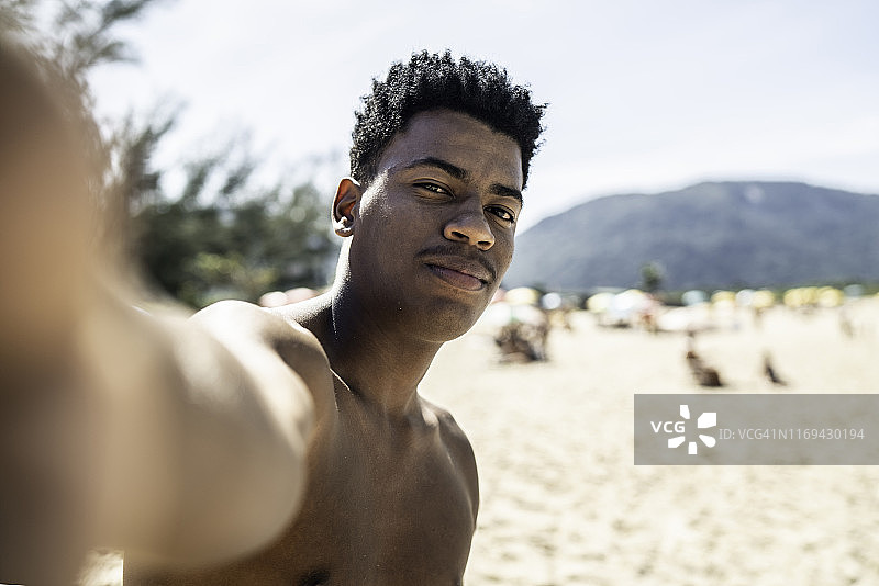 在海滩上的年轻男子自拍图片素材