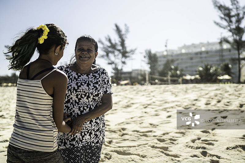 孙女和奶奶在海滩上手牵着手图片素材