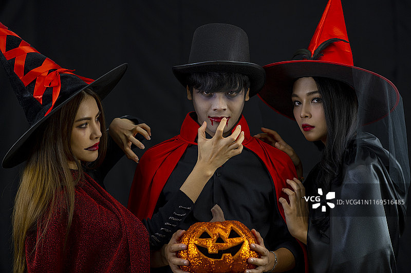 年轻快乐的朋友们在万圣节派对上做鬼脸庆祝图片素材