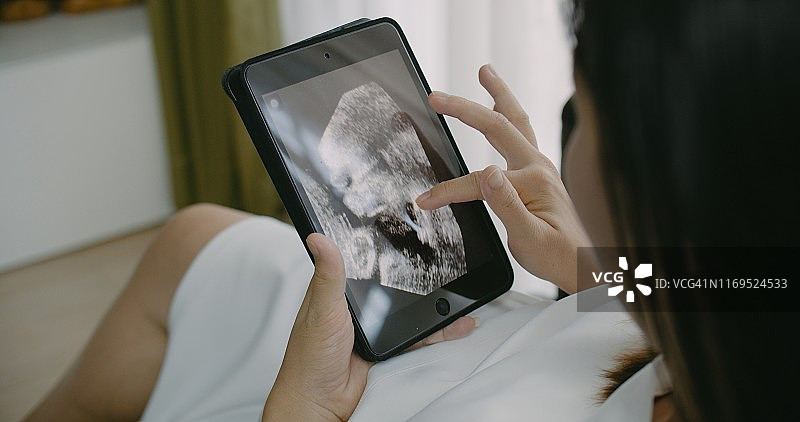 孕妇用平板电脑看电影图片素材