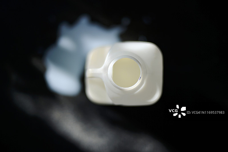 洒落的牛奶和塑料奶瓶图片素材