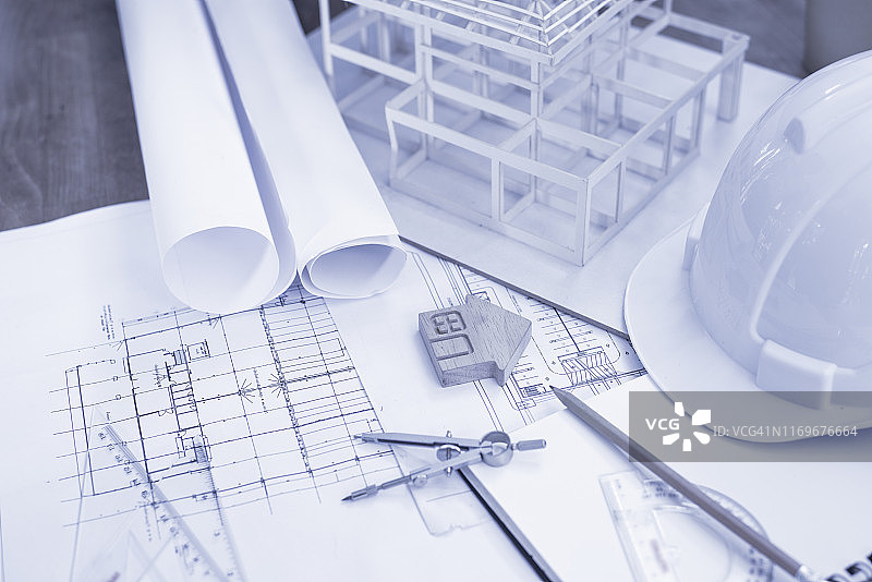 建筑师办公室的办公桌上的蓝图和建筑设备，蓝色调的建筑师概念图片素材
