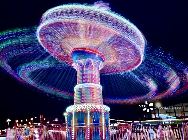 在灯火通明的旋转木马上的人们图片素材