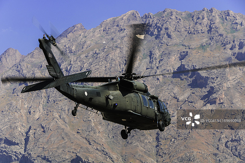 军用通用直升机飞越山脉图片素材