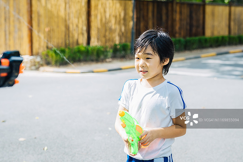花园里的水枪大战，孩子们玩得很开心图片素材