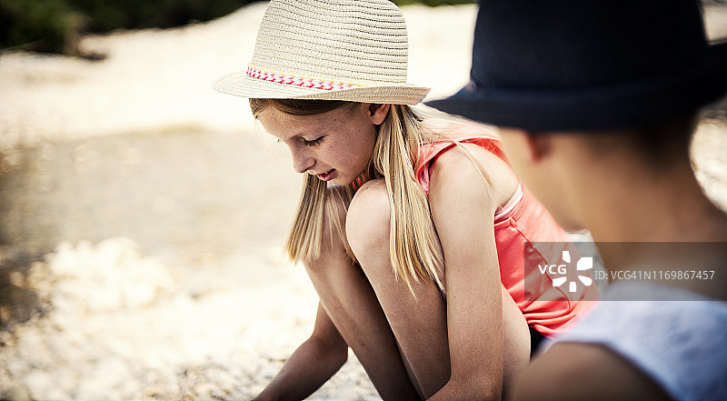 兄妹在河边堆叠石头图片素材