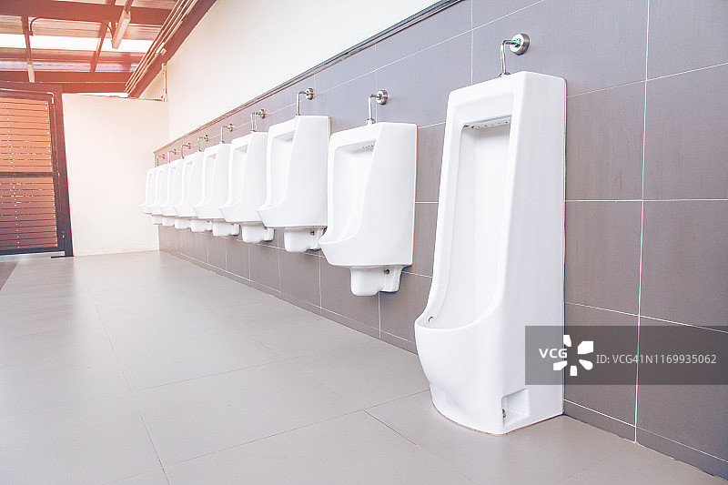男洗手间内一排白色瓷小便池图片素材