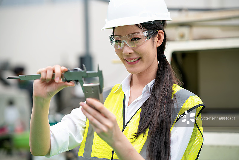 女工程师用游标卡尺测量零件尺寸图片素材