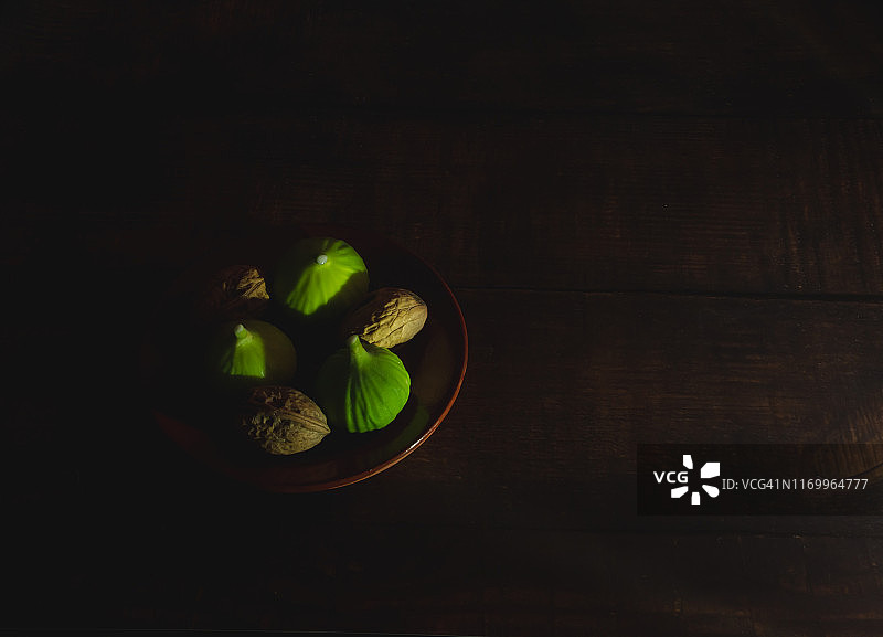 秋季水果：陶盘上新鲜采摘的青色无花果和坚果图片素材