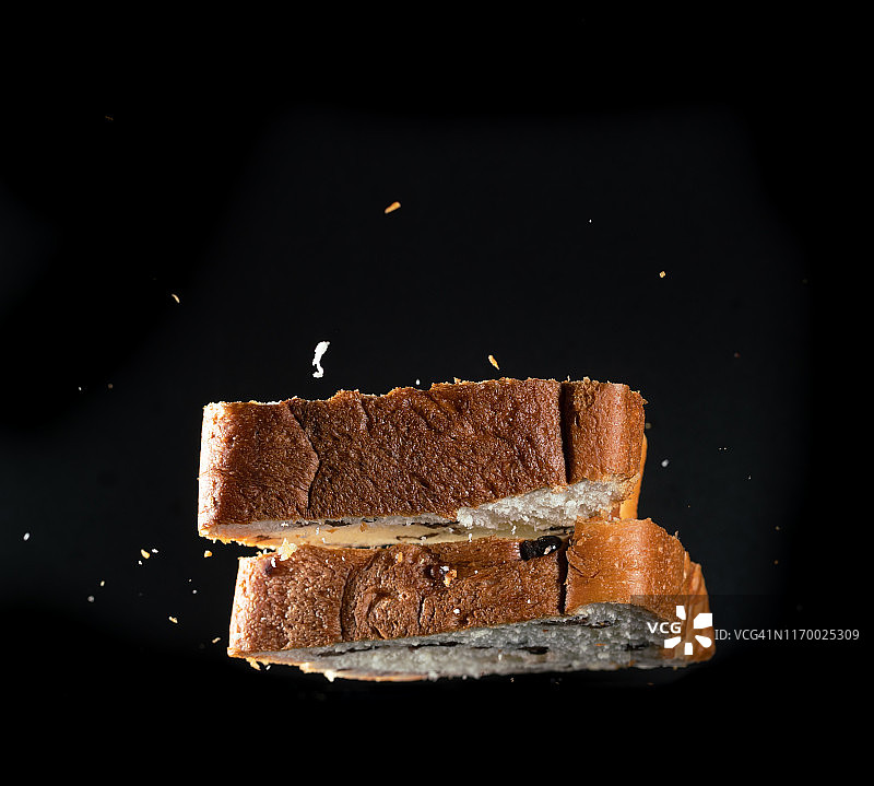 高速同步拍摄的红豆吐司，黑色背景图片素材