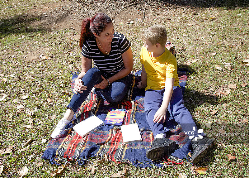 家庭时光：阿姨在阳光下与侄子一起读书图片素材