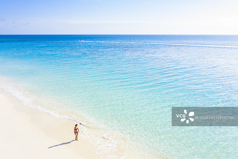 在加勒比安的列斯群岛沙滩上散步的女人图片素材