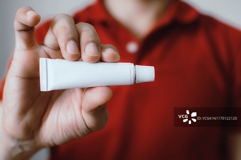 一位年轻男子正在使用医用药膏图片素材