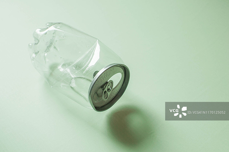 绿色背景下的塑料苏打水罐图片素材
