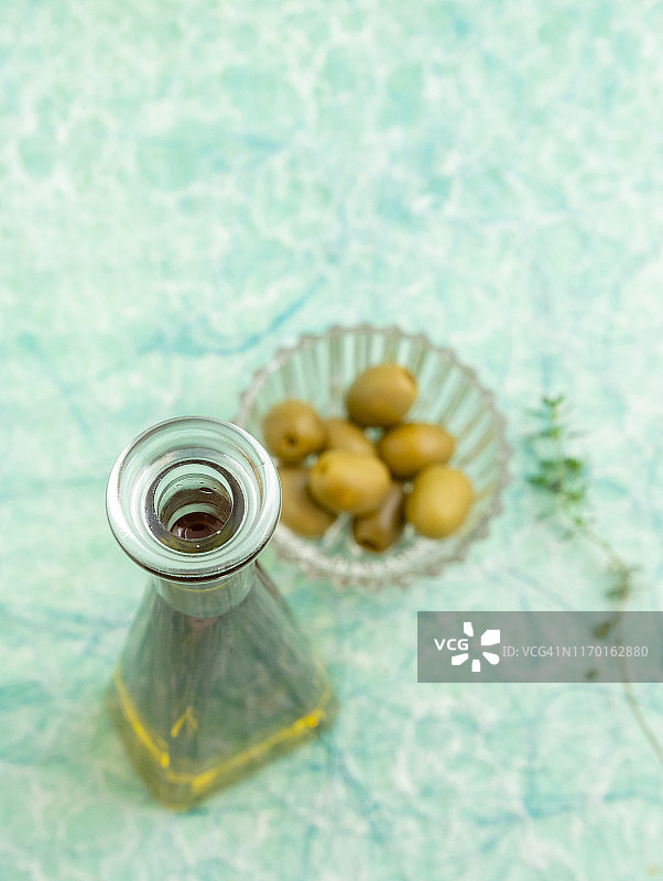 特级初榨橄榄油、绿色橄榄和百里香图片素材