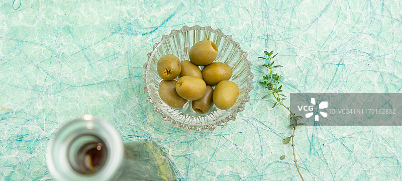 特级初榨橄榄油、绿色橄榄和百里香图片素材