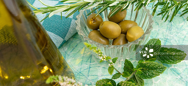 特级初榨橄榄油、绿色橄榄、迷迭香和薄荷图片素材