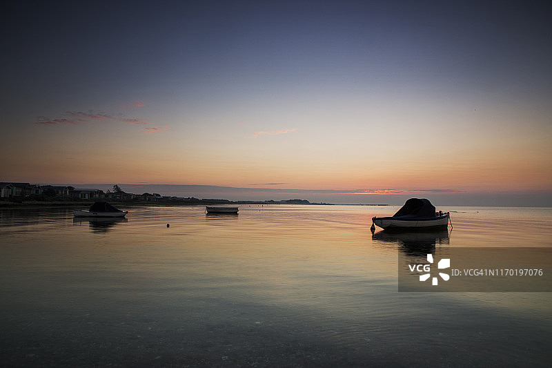 澳大利亚维多利亚州墨尔本南威勒比坎贝尔斯湾的菲利普港日出时船只的倒影图片素材
