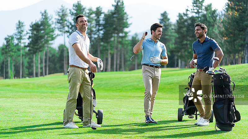 朋友们在阳光明媚的日子里打高尔夫图片素材