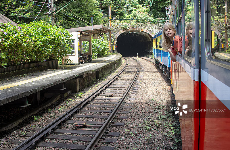 在日本箱根的火车上玩耍的金发男孩图片素材
