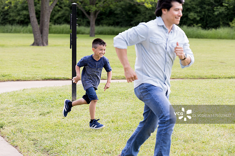 小男孩追着爸爸玩棒球图片素材