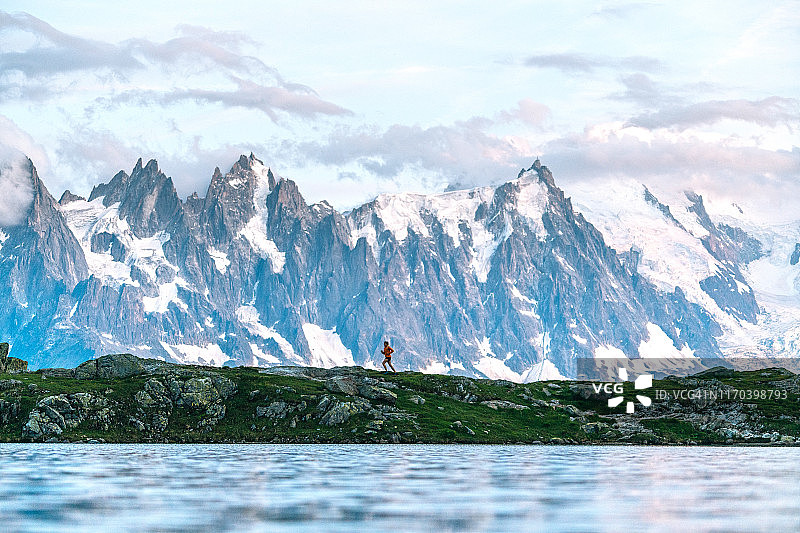 年轻女子在山下湖边奔跑图片素材